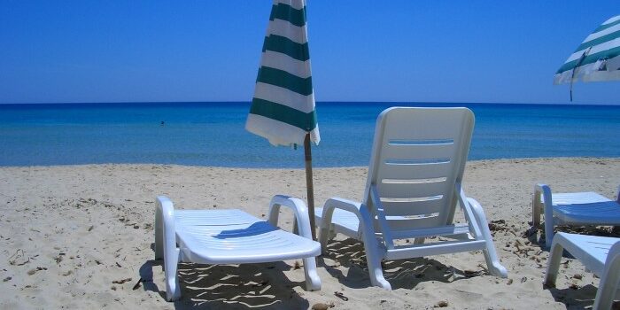 Strandliegen und Sonnenschirme am Strand.